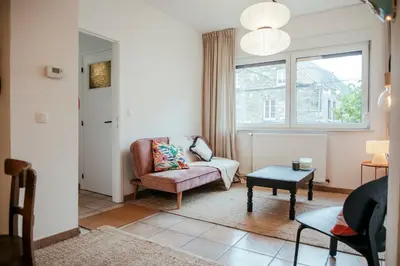 a living room with a couch and a chair at La Courte Échelle in Verviers