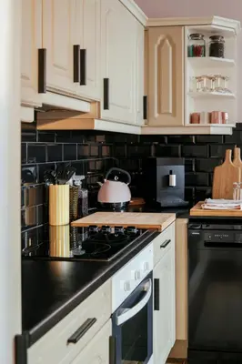 a kitchen with white cabinets and a stove top oven at La Courte Échelle in Verviers
