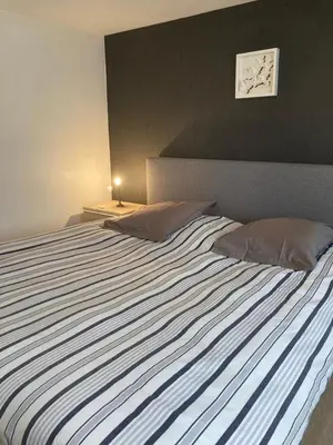a bedroom with a large bed with a striped blanket at Chambre d hote in Olne