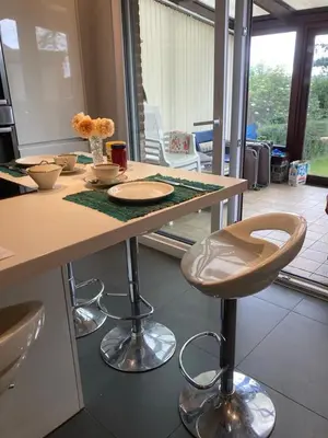 a kitchen with a counter with chairs and a table at Chambre d hote in Olne