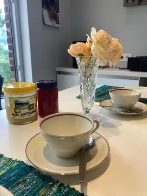 a table with two plates and a vase with flowers at Chambre d hote in Olne