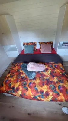 a large bed with a flower blanket on it at Puck B&B Babbita in Hasselt