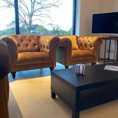 a brown leather couch in a living room with a coffee table at DeStoker in Hasselt