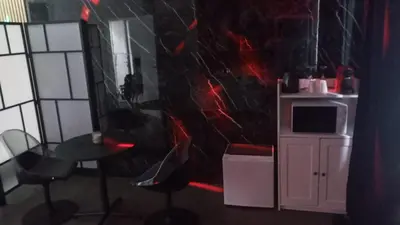 a room with a black wall with a table and chairs at La Suite Gold Wellness Jacuzzi & Sauna in Seraing