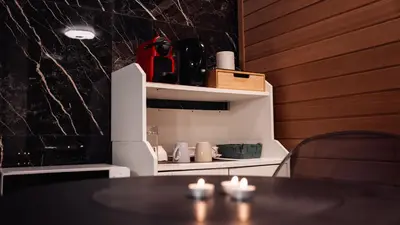 a dining room with a table and a shelf with candles at La Suite Gold Wellness Jacuzzi & Sauna in Seraing