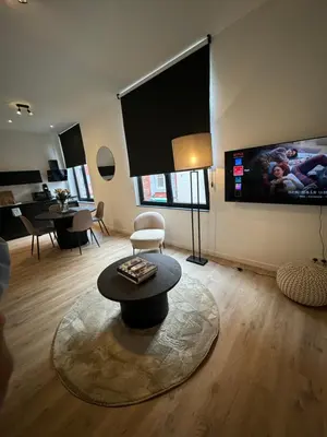 a living room with a table and a flat screen tv at Urbanchic Opéra 2B in Liège