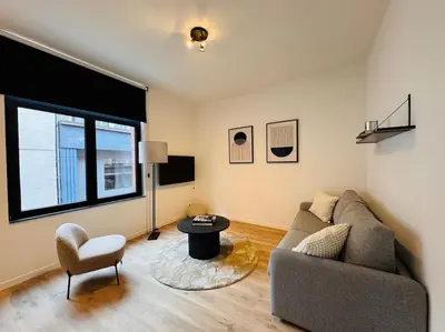 a living room with a couch and a table at Urbanchic Opéra 2B in Liège