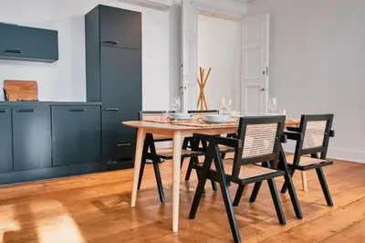 a dining room with a wooden table and chairs at Urbanchic Appartement élégance hyper centre in Liège