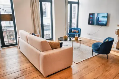 a living room with a couch and a tv at Urbanchic Appartement élégance hyper centre in Liège