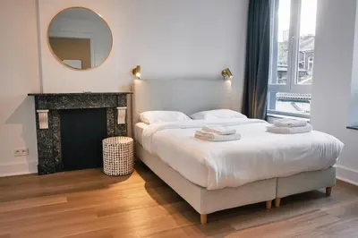 a bedroom with a bed with a fireplace and a mirror at Urbanchic atmosphère 2D in Liège