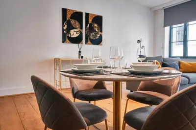 a living room with a table with chairs and a couch at Urbanchic atmosphère 2D in Liège