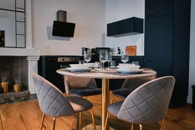 a dining room table with chairs and wine glasses at Urbanchic atmosphère 2D in Liège