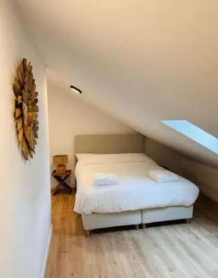 a bedroom with a white bed in a attic at Urbanchic Appartement Evasion 3D in Liège