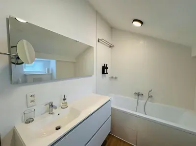 a white bathroom with a sink and a mirror at Urbanchic Appartement Evasion 3D in Liège