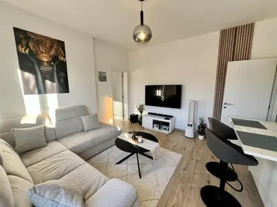 a living room with a couch and a table at Modern Business Flat - Courts et moyens séjours in Liège