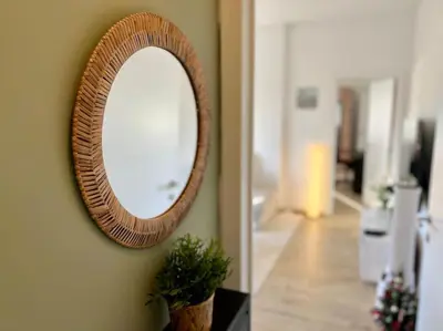 a mirror hanging on a wall in a living room at Modern Business Flat - Courts et moyens séjours in Liège