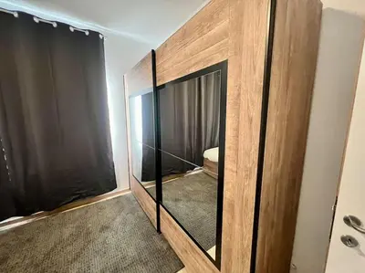 a room with a large wooden cabinet with a mirror at Modern Business Flat - Courts et moyens séjours in Liège