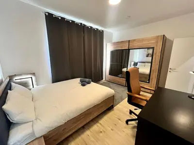 a bedroom with a bed and a desk and a chair at Modern Business Flat - Courts et moyens séjours in Liège