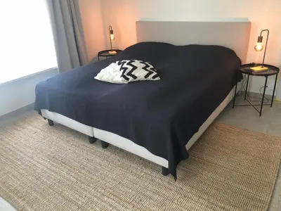 a bed with a black and white pillow on it at Puur17 in Lommel