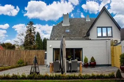 a table and chairs in front of a house at B&B Noord-Zuid in Zonhoven
