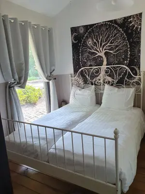 a bedroom with a bed with a tree mural on the wall at B&B Land of Tir Nan Og in Lommel