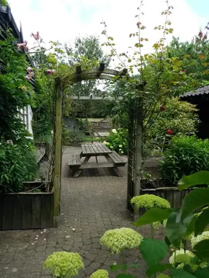 a garden with a picnic table and a bench at B&B Land of Tir Nan Og in Lommel
