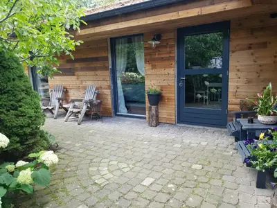 a patio with a blue door and a table and chairs at B&B Land of Tir Nan Og in Lommel