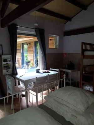a bedroom with a bed and a table and chairs at B&B Land of Tir Nan Og in Lommel