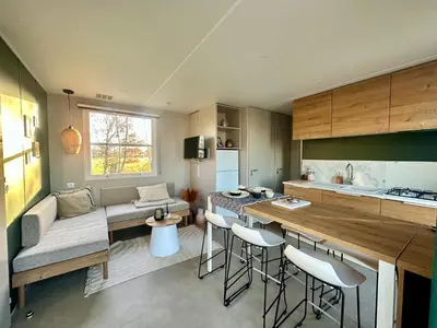 a kitchen and living room with a couch and a table at Vakantiehuis 25 min Roermond Maasmechelen Maastricht in Kinrooi