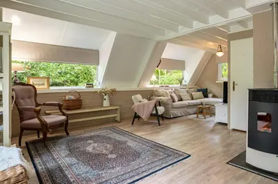 a living room with a couch and a fireplace at Boshuisje Rekem - Fleur in Lanaken