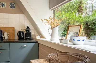 a kitchen with a window with vases on a counter at Boshuisje Rekem - Fleur in Lanaken