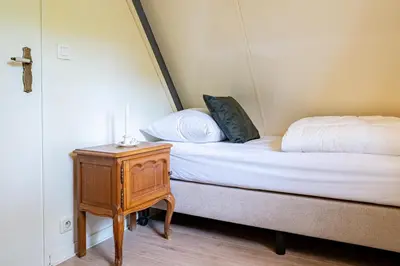 a bedroom with a bed and a nightstand next to a bed at Boshuisje Rekem - Fleur in Lanaken