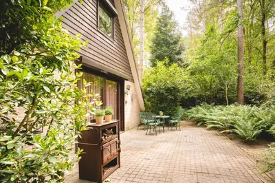a patio with a table and chairs and a house at Boshuisje Rekem - Fleur in Lanaken
