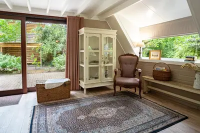 a living room with a chair and a window at Boshuisje Rekem - Fleur in Lanaken