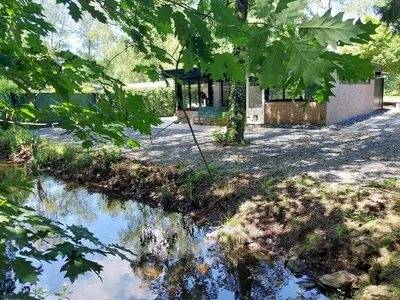 a pond in front of a house with a gazebo at Opeteukske in Lanaken