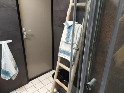 a wooden ladder in a shower with towels on it at Opeteukske in Lanaken