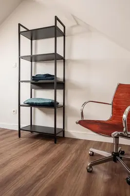 a room with a chair and a shelf at ViaAmbioriX in Tongeren