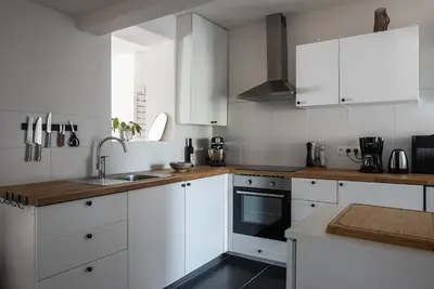 a white kitchen with white cabinets and a sink at ViaAmbioriX in Tongeren