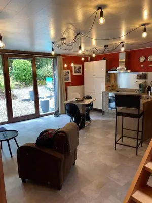 a living room with a couch and a kitchen at Au nid douillet in Trooz