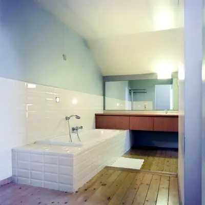 a bathroom with a tub and a large mirror at A la Maison in Heks