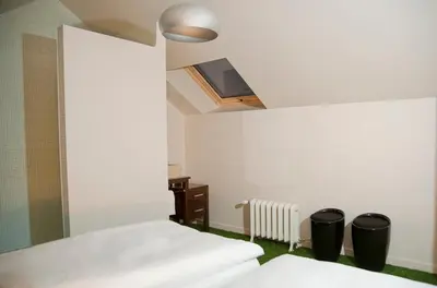 a bedroom with two beds and a tv on the ceiling at A la Maison in Heks