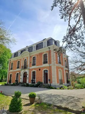 a large red brick building with windows on top at Le Petit Château Peltzer in Verviers