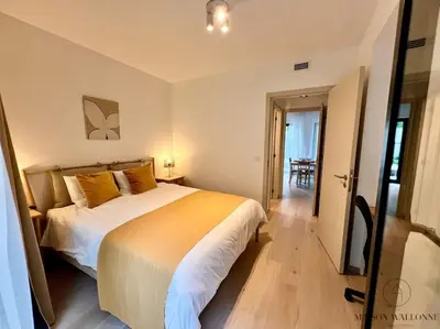 a bedroom with a large bed and a sliding glass door at Le paisible écrin - Hypercentre avec Parking in Liège