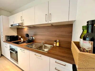 a kitchen with white cabinets and a sink at Le paisible écrin - Hypercentre avec Parking in Liège