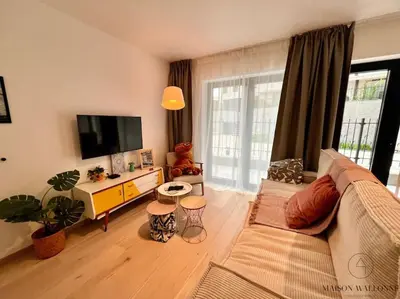 a living room with a couch and a flat screen tv at Le paisible écrin - Hypercentre avec Parking in Liège