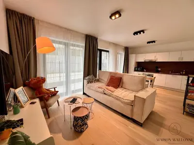 a living room with a couch and a table at Le paisible écrin - Hypercentre avec Parking in Liège