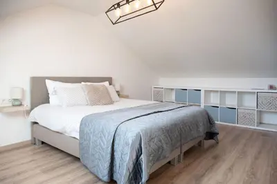 a bedroom with a large bed with blue and white at Vakantiewoning Huis 8 in Tongeren