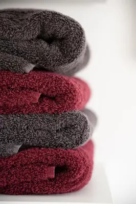 a stack of red and gray towels on a table at Vakantiewoning Huis 8 in Tongeren