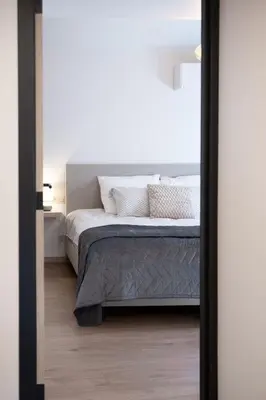 a bedroom with a bed with white sheets and pillows at Vakantiewoning Huis 8 in Tongeren