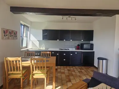 a kitchen with a table and chairs in a room at Appartement à la campagne in Juprelle